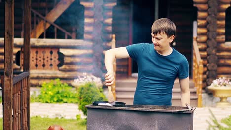 Un-Hombre-En-Cámara-Lenta-Cocina-Pilaf-En-Un-Caldero-Sobre-Brasas-En-Una-Parrilla-Y-Remueve-La-Carne