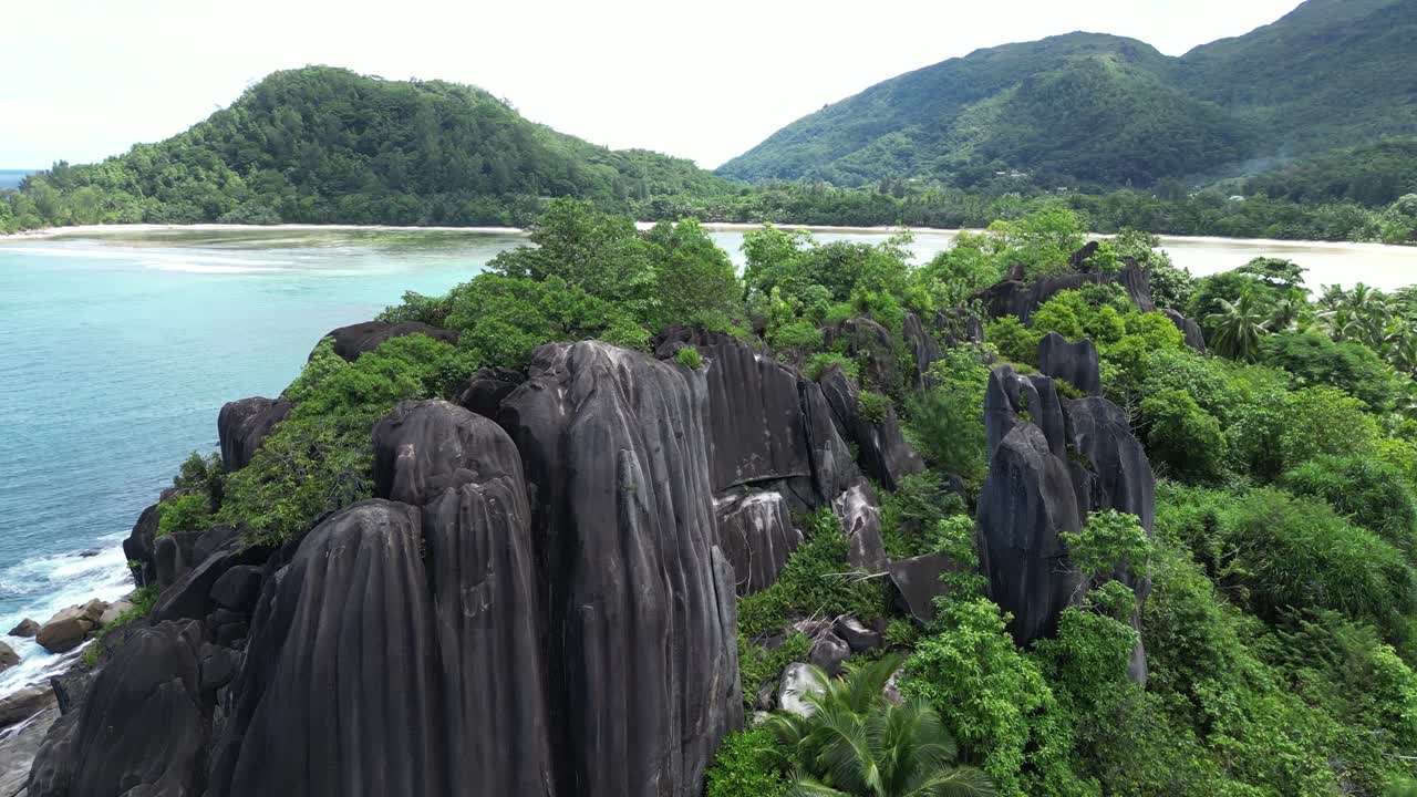 Aerial View of Tropical Island Beach with Lush Greenery and Granite Rocks