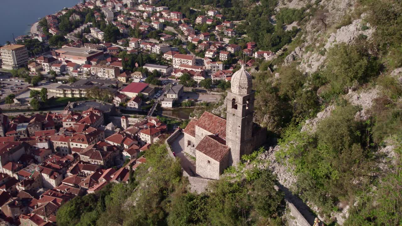 Città medievale con sentiero in pietra, chiesa e foresta, vista sulla Baia di Cattaro, Montenegro