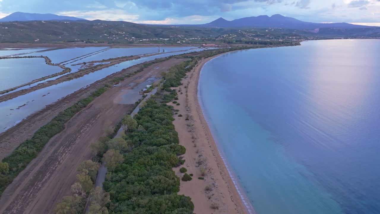 Veduta aerea del bagliore del tramonto sul mare calmo con spiaggia e costa a Pylos