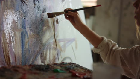 Woman-hand-drawing-in-studio.-Inspired-painter-holding-paintbrush-indoors.