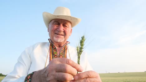 satisfied and Happy Grandfather in Hat and Embroidered Shirt Holding Ear of Corn and Looking at Satisfied and Happy Grandfather in Hat and Embroidered Shirt Holding Ear of Corn and Looking at Camera Happy People