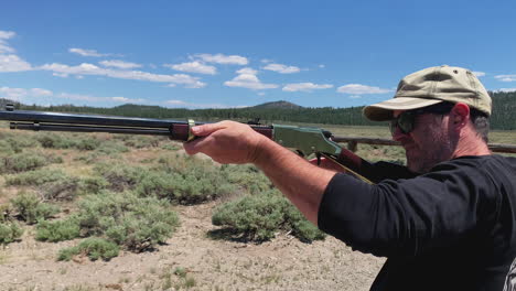 hombre disparando vieja palanca de oro acción 22 rifle pintoresco campo de tiro al aire libre