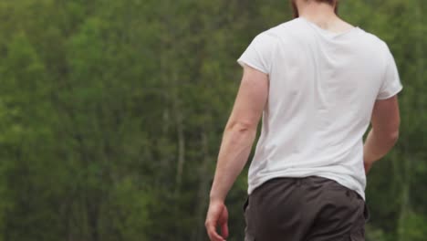 la naturaleza desenfocada con un hombre que muestra músculos está sosteniendo un hacha