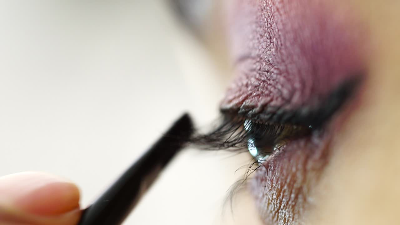 Applying eyeliner and eyeshadow - Close up of woman's eye makeup