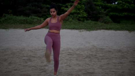 Young-Indian-Female-Adult-With-Open-Arms,-Standing-Exercise-On-Beach