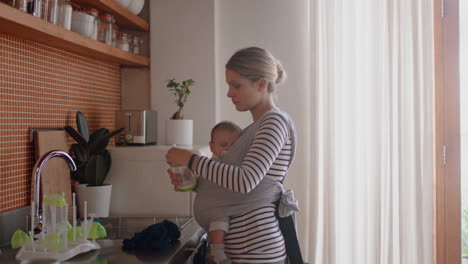 Madre-Joven-Sosteniendo-Al-Bebé-Dormido-En-Casa-Limpiando-La-Cocina-Trabajando-En-Tareas-Domésticas-Mamá-Disfrutando-De-La-Responsabilidad-De-La-Maternidad-Cuidando-Al-Niño