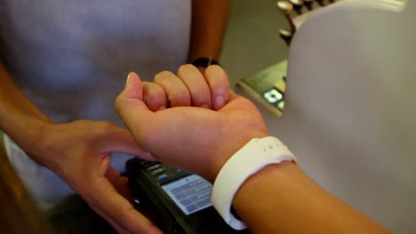 cliente haciendo pago a través de smartwatch 4k