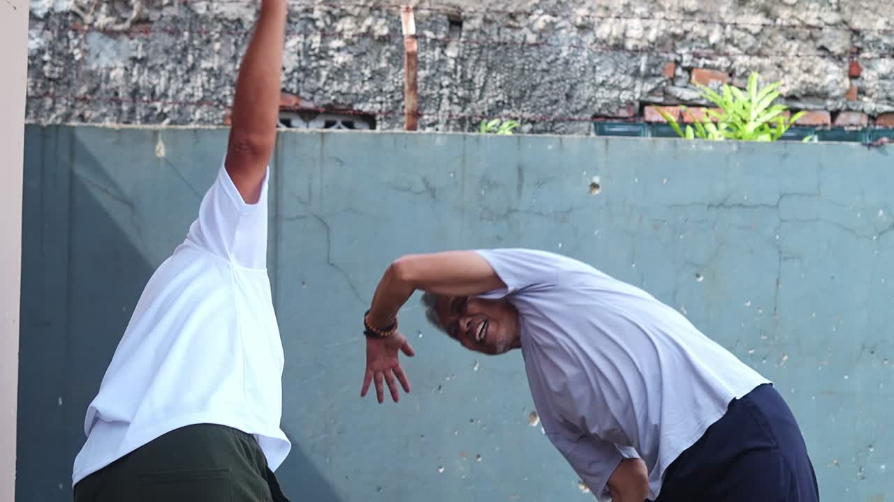 Due uomini asiatici anziani che fanno stretching e condividono un momento all'aperto
