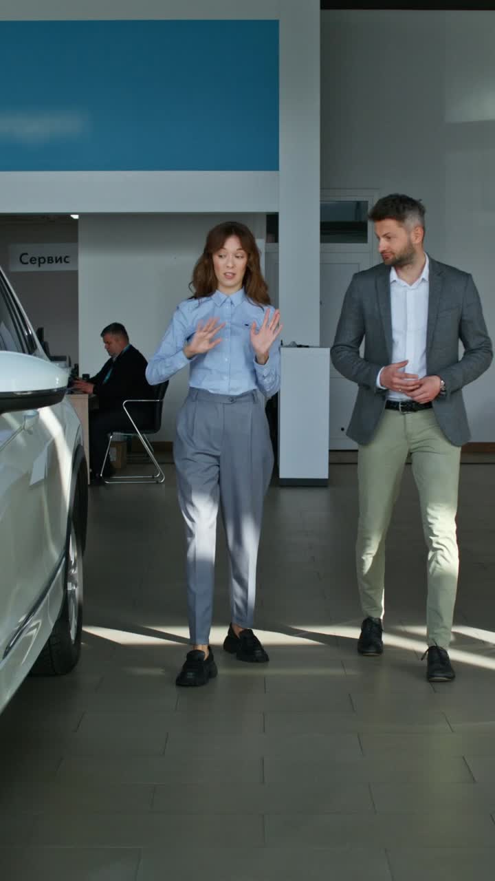 vendedor de automóviles discutiendo un vehículo con un cliente en una sala de exposiciones