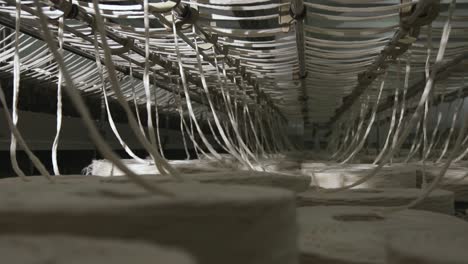 spools of yarn being spun into thread in a textiles production mill