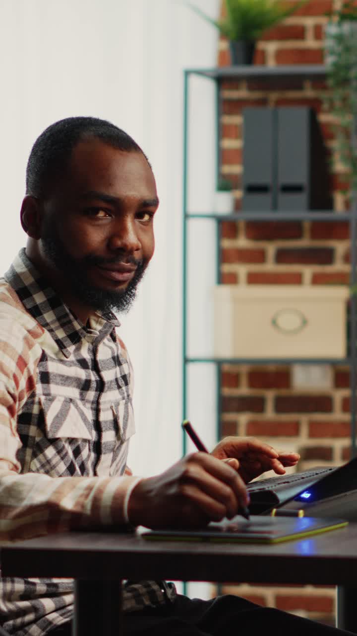 Vertical video: Smiling professional 3d artist working with graphic tablet