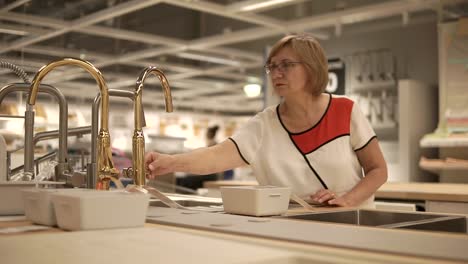 woman shopping for kitchen faucet and sink