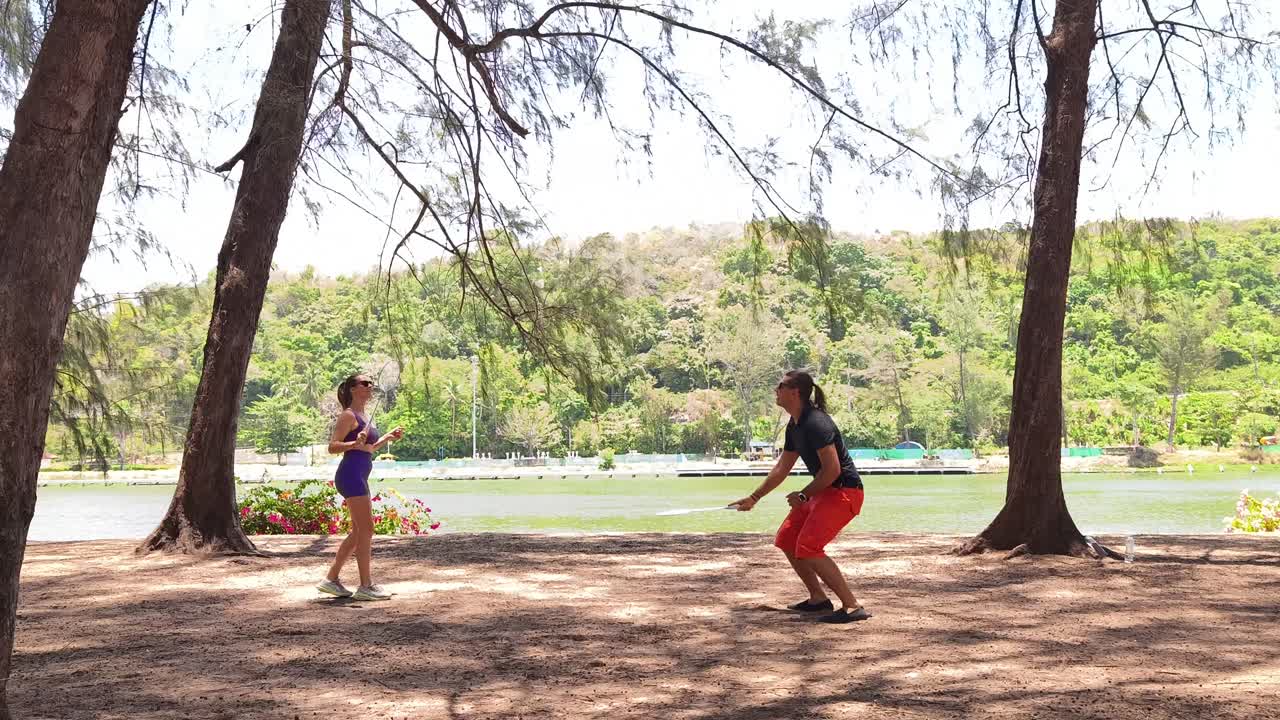 Couple Playing Badminton by the Lake