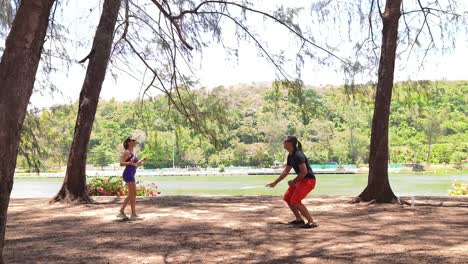 couple playing badminton by the lake