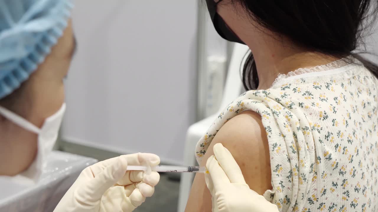 el personal médico asiático administra la vacuna, cierra