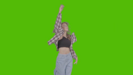 studio shot of young woman having fun dancing against green screen 23