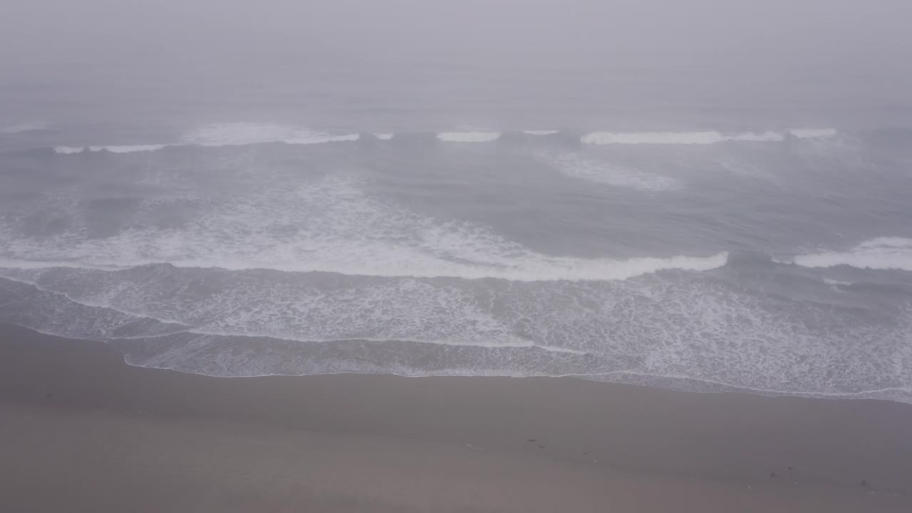 Dramatic Ocean Waves Crashing on a Misty Beach