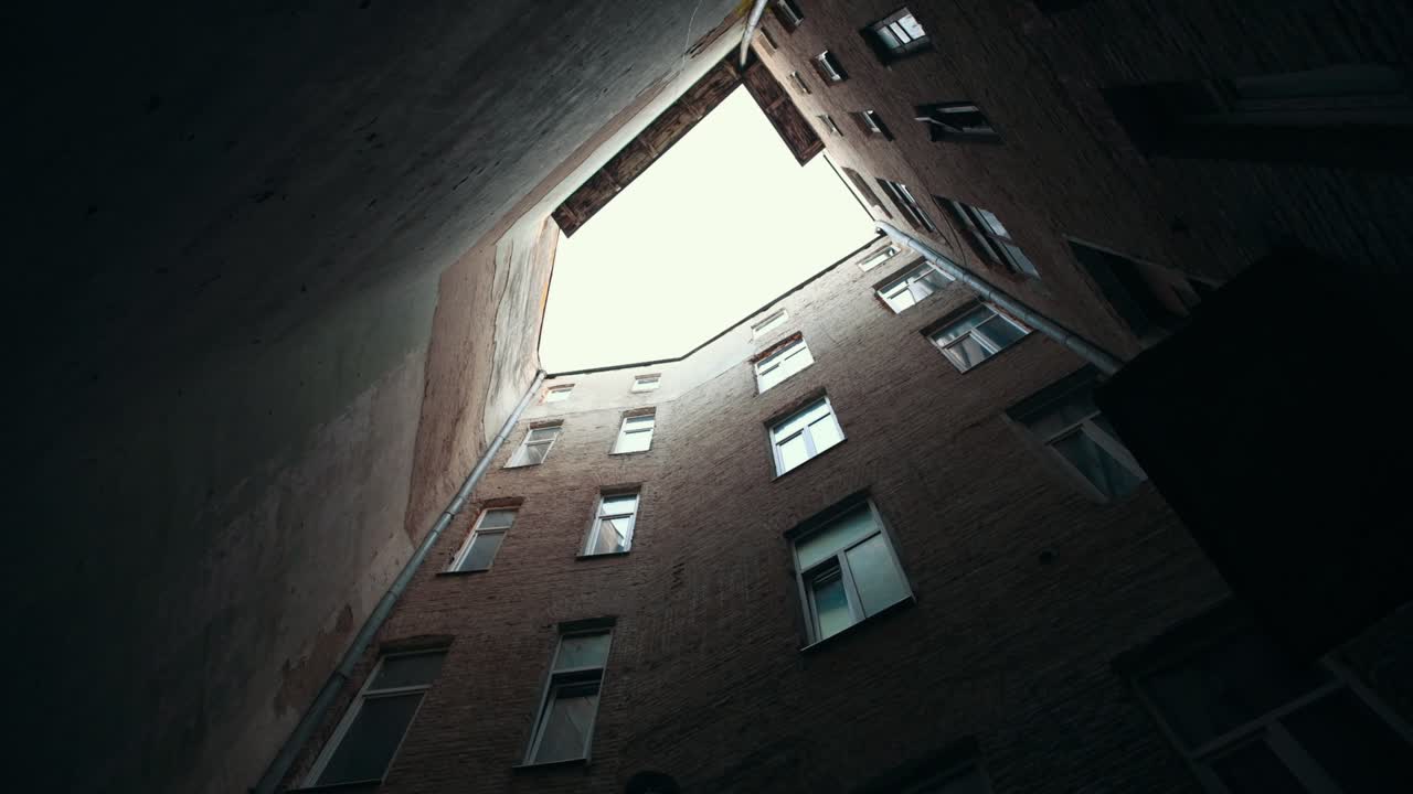 vista de un edificio antiguo en un patio estrecho. luz natural del día. tiempo nublado. mirando hacia arriba
