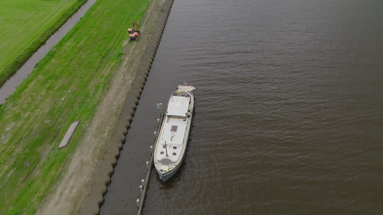 Oblique approach to a Dutch canal drawbridge with small boats at the dolphins and a road crossing over the span