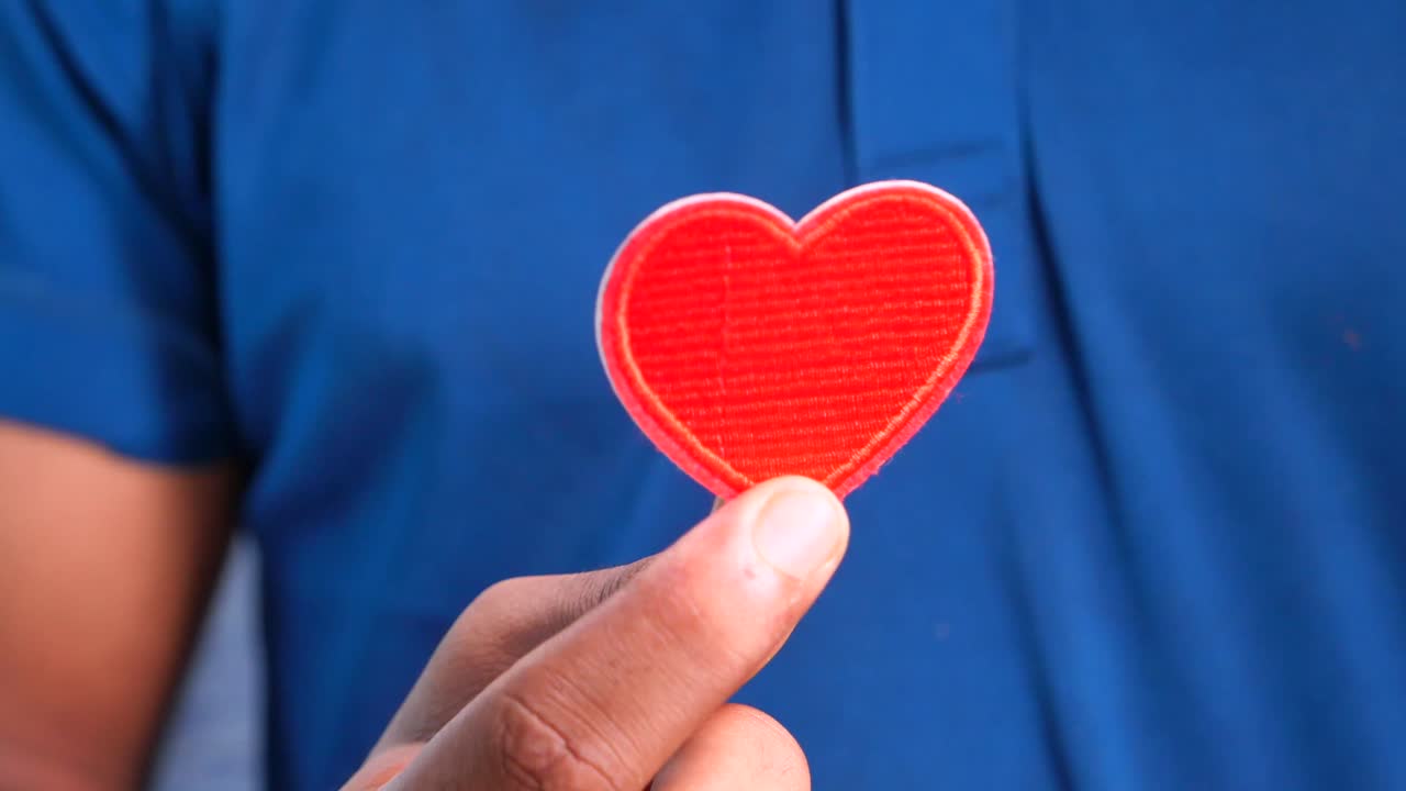 빨간색 심장 패치를 들고 있는 사람