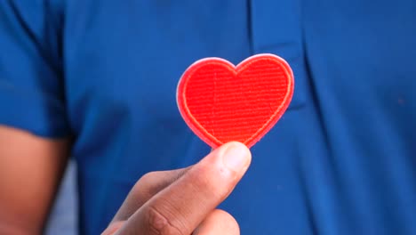 persona que sostiene un parche de corazón rojo