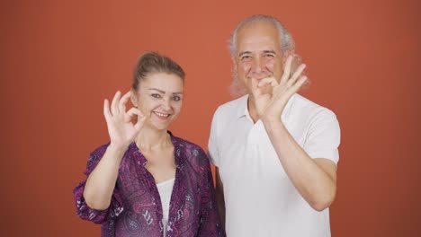 una pareja haciendo un gesto positivo a la cámara.