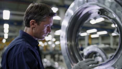 factory worker inspecting metal component