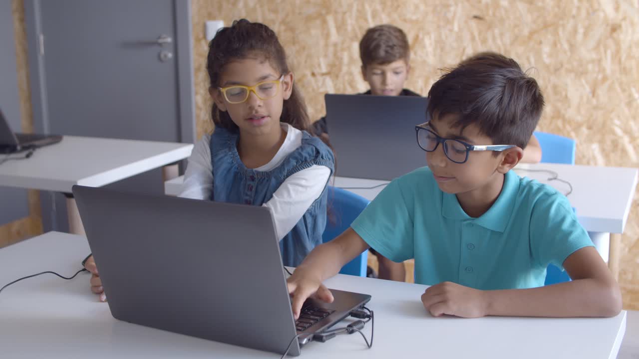 dos compañeros de clase con gafas colaborando en la tarea