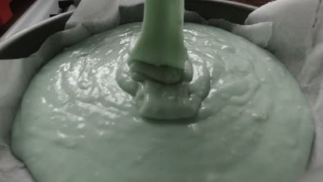 falling creamy smooth raw cake batter mixture into kitchen cooking pan slow motion