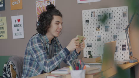 young person using smartphone and laptop at home