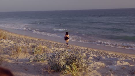 woman running on beach at sunset