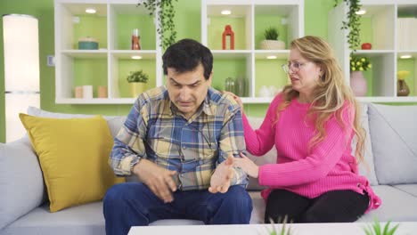 Woman-trying-to-comfort-and-make-her-sad-husband-happy.