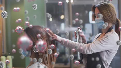 animación de células de coronavirus sobre una peluquera caucásica y una mujer que usa máscaras faciales