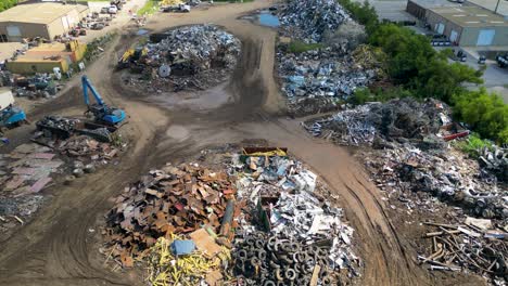 slow-rising-drone-view-above-scrapyard-on-a-bright-sunny-day