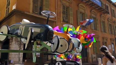 vintage toy cars and windmills on display in a european city street