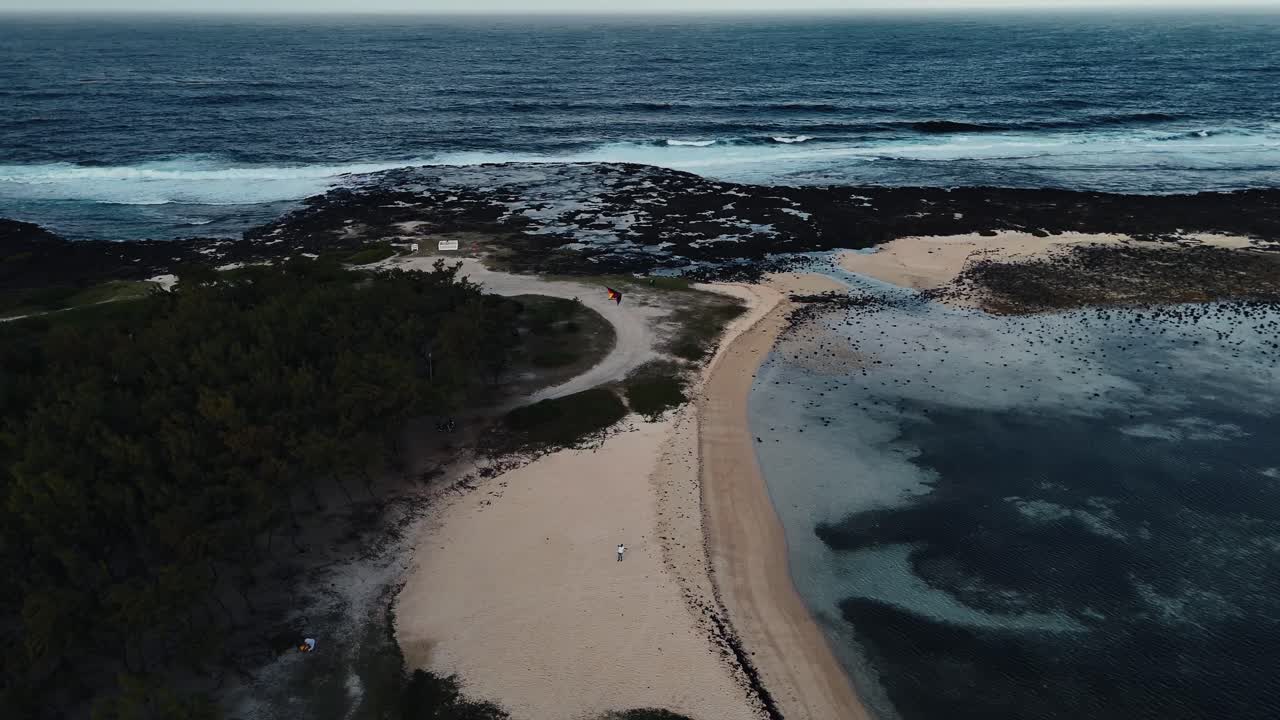 Aerial view of a Mauritius beach and bay, following a kite flying high over the dramatic coastline. Concept of adventure sports, freedom, and wild tropical landscapes