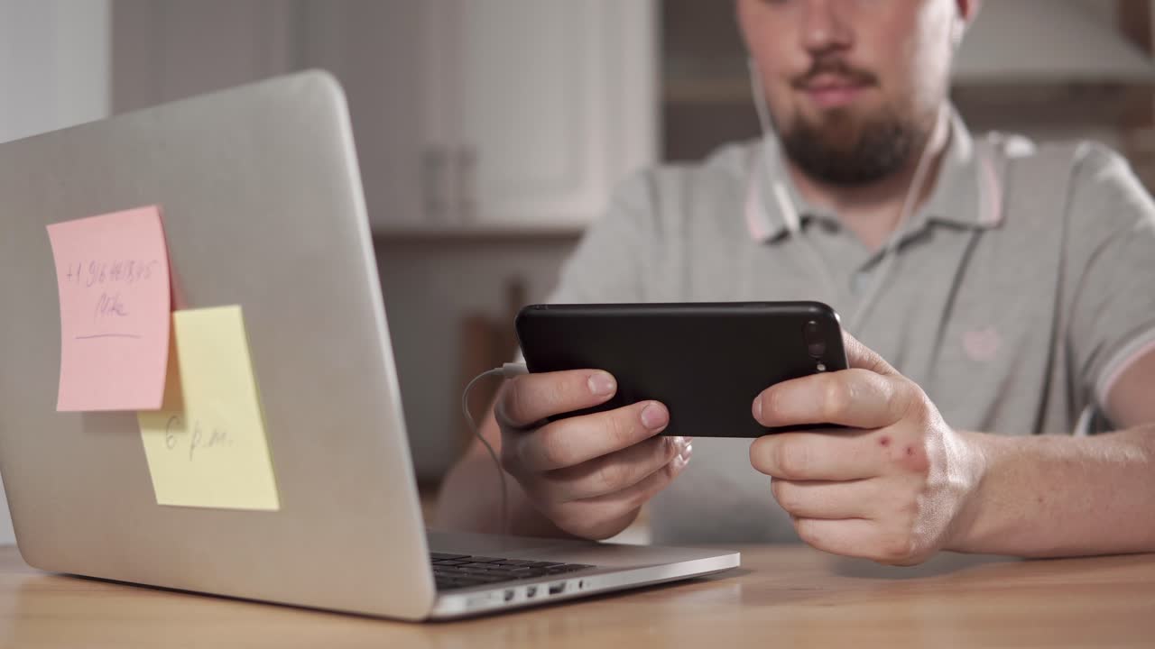 persona que utiliza una computadora portátil y un teléfono inteligente en el hogar