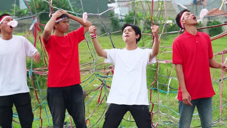 group of indonesian young men excitedly participates in traditional cracker eating race to celebrate independence day