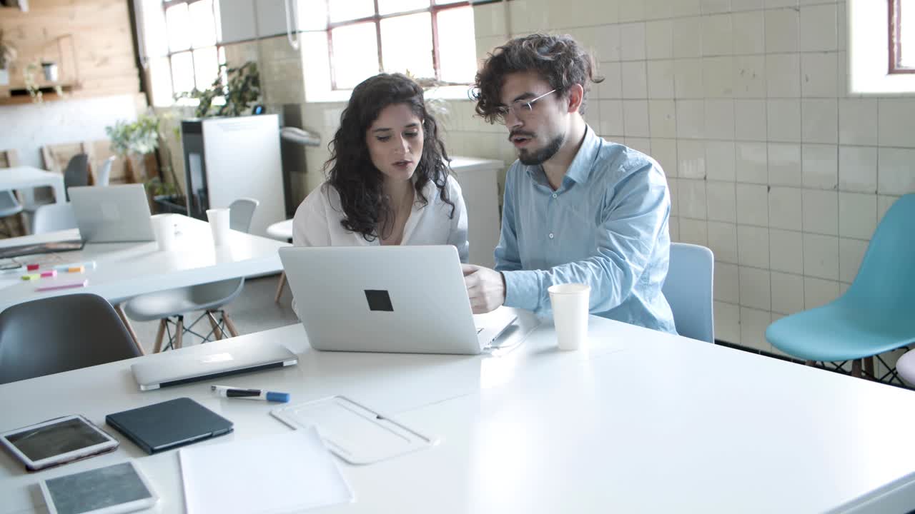 Jóvenes colegas pensativos discutiendo un proyecto