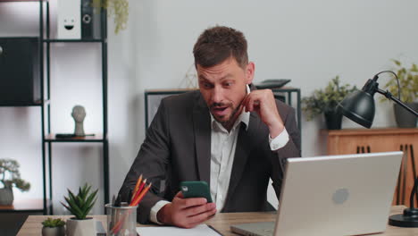 Hombre-De-Negocios-Terminando-Una-Llamada-Telefónica-Vendiendo-En-Línea-Usando-Un-Teléfono-Inteligente-Victoria-Recibiendo-Buenas-Noticias