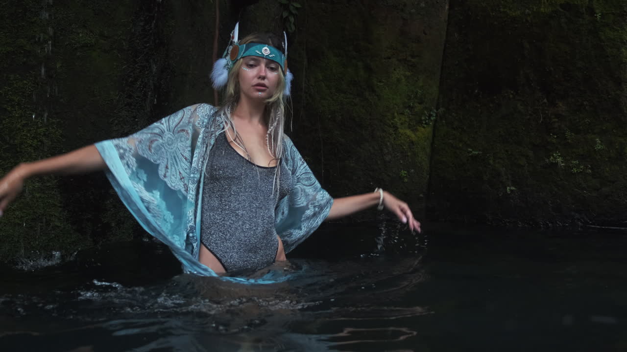 Woman in nature, posing in a waterfall