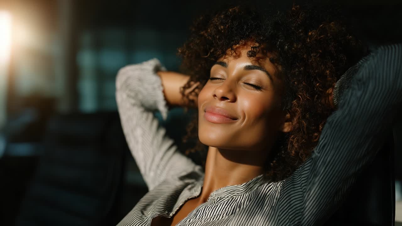 A woman relishing a serene moment of relaxation, exuding tranquility and joy as she sits back with her eyes closed, allowing the comforting ambiance around her to wash over her, creating a perfect moment of peace