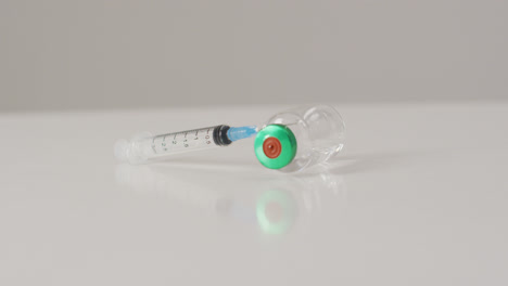 video de un primer plano del vial de vacuna sobre un fondo blanco