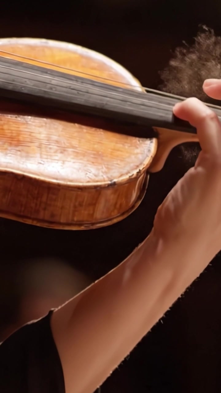 A Close-Up of a Violinist's Hand Skillfully Holding a Beautifully Crafted Violin During an Engaging Musical Performance, Showcasing Artistic Talent and Emotion
