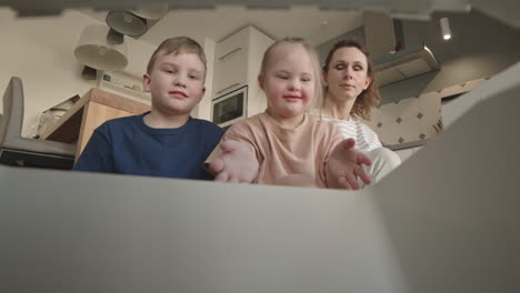 family opening a box in the kitchen