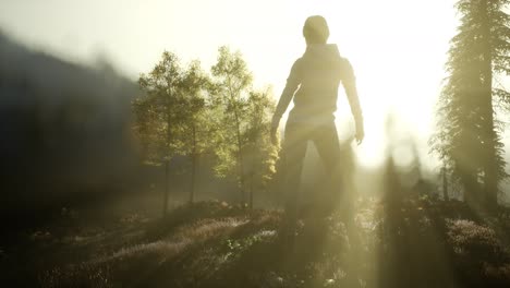 young woman standing alone outdoor with wild forest mountains