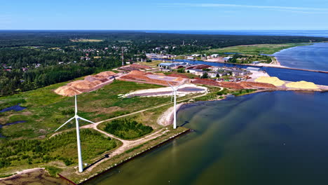 aerial view of wind turbines and industrial port in the background