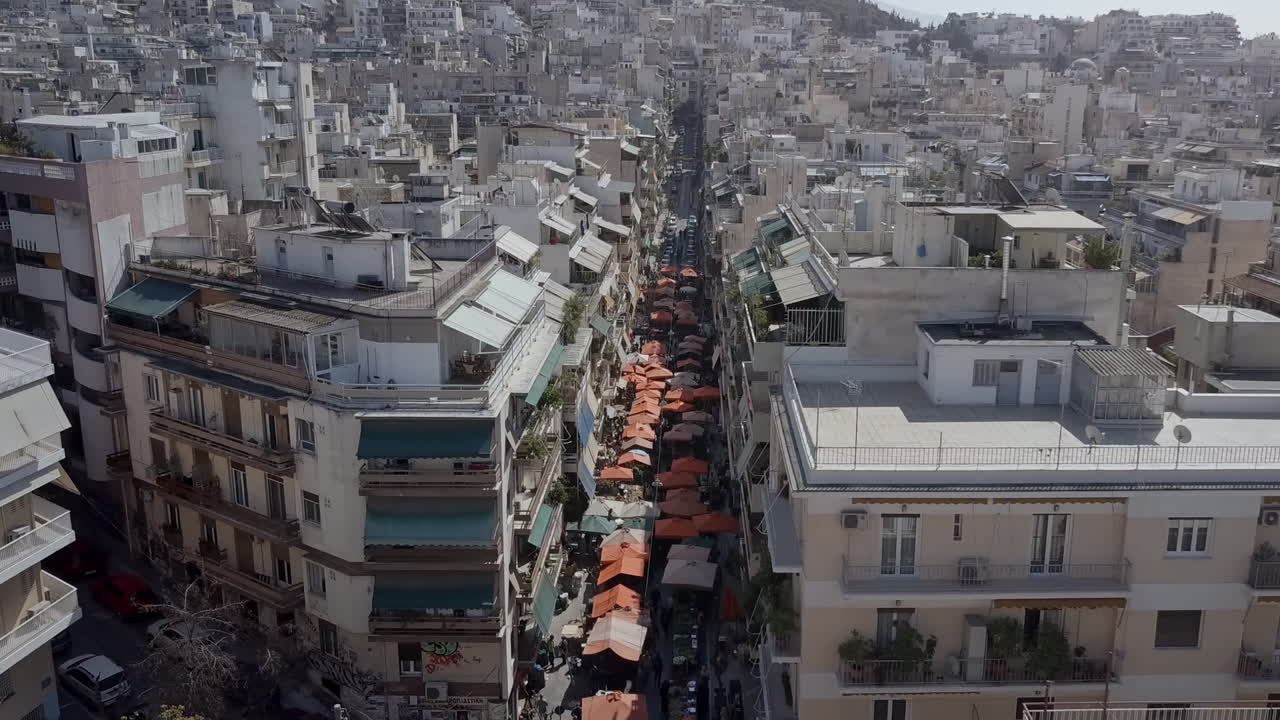 Ripresa aerea con drone lungo un mercato di strada ad Atene, Grecia, con panoramica verso il basso.
