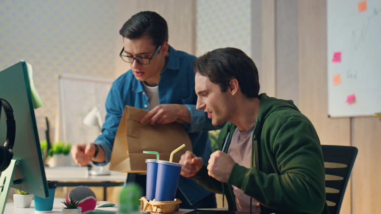 주린 프리랜서가 저녁을 기다리고 가 테이블을 때립니다. 사무실 사람들이 주먹을 맞추고 있습니다.